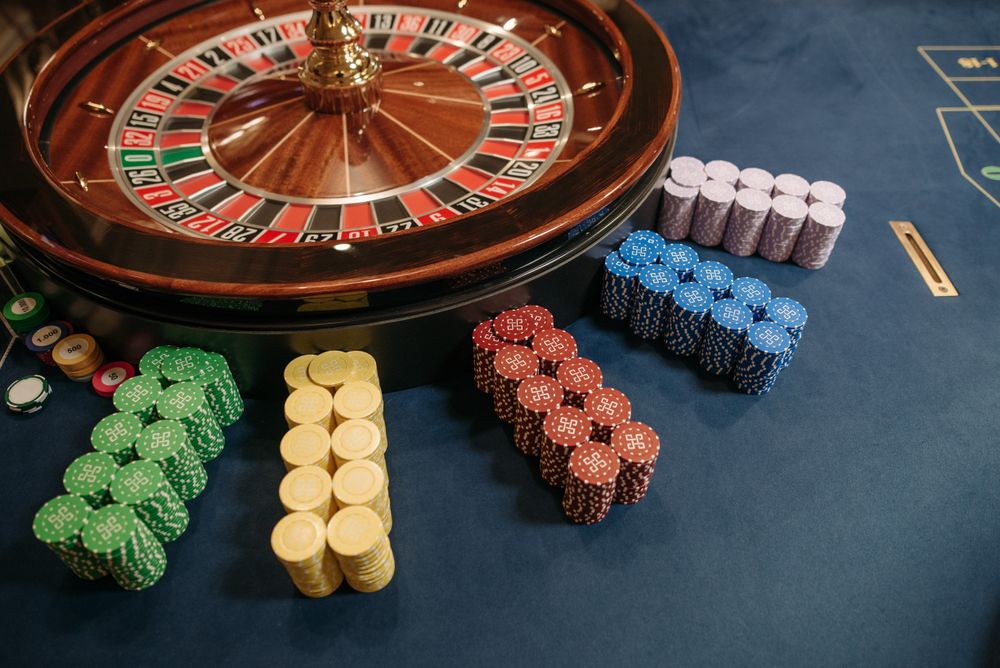 Meja roulette casino dengan tumpukan chip permainan