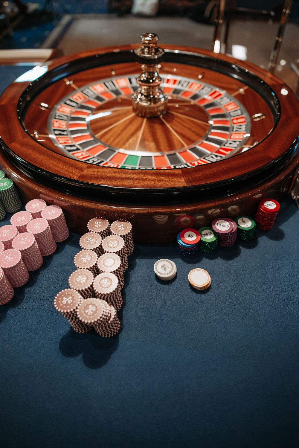 Meja roulette dengan tumpukan chip kasino warna-warni